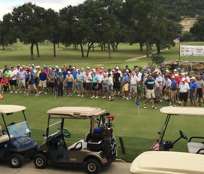 Large group photo of about 50 golfers on a golf course