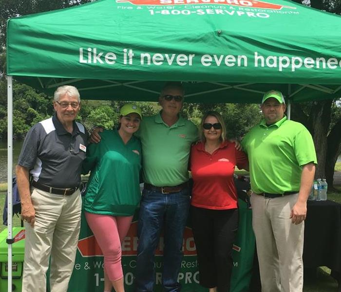 Group photo of golfers under SERVPRO tent